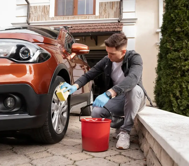 Lavage auto à domicile Granges-les-Beaumont : professionnel intervenant sur un véhicule